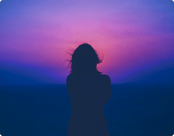 A silhouette of a women in front of a sunset