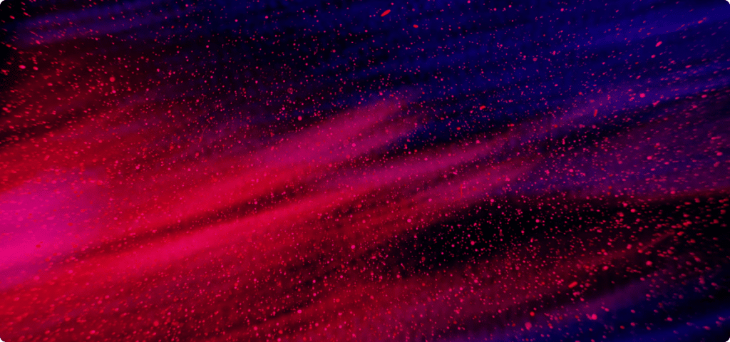 An image showing a spray of pink powder on a dark background