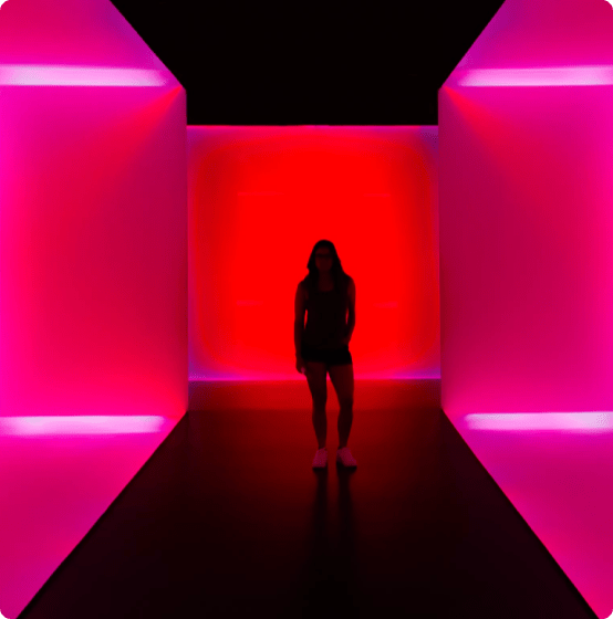 A silhouetted woman in a room with red walls