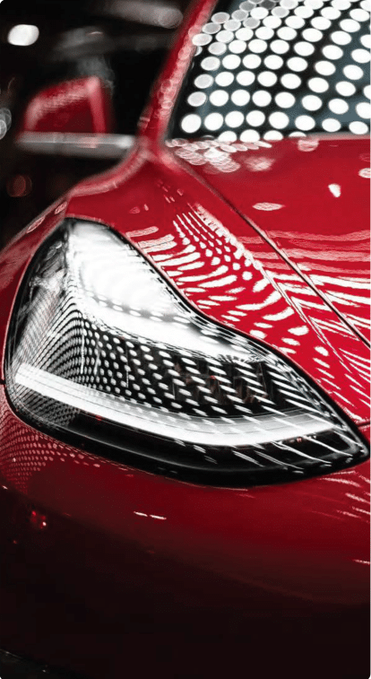A close up of a red cars headlight